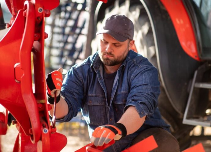 The farmer repairs agricultural machines